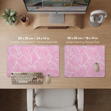 Pastel pink desk mat with a marble-style design, white flowing lines, and small sparkle accents.