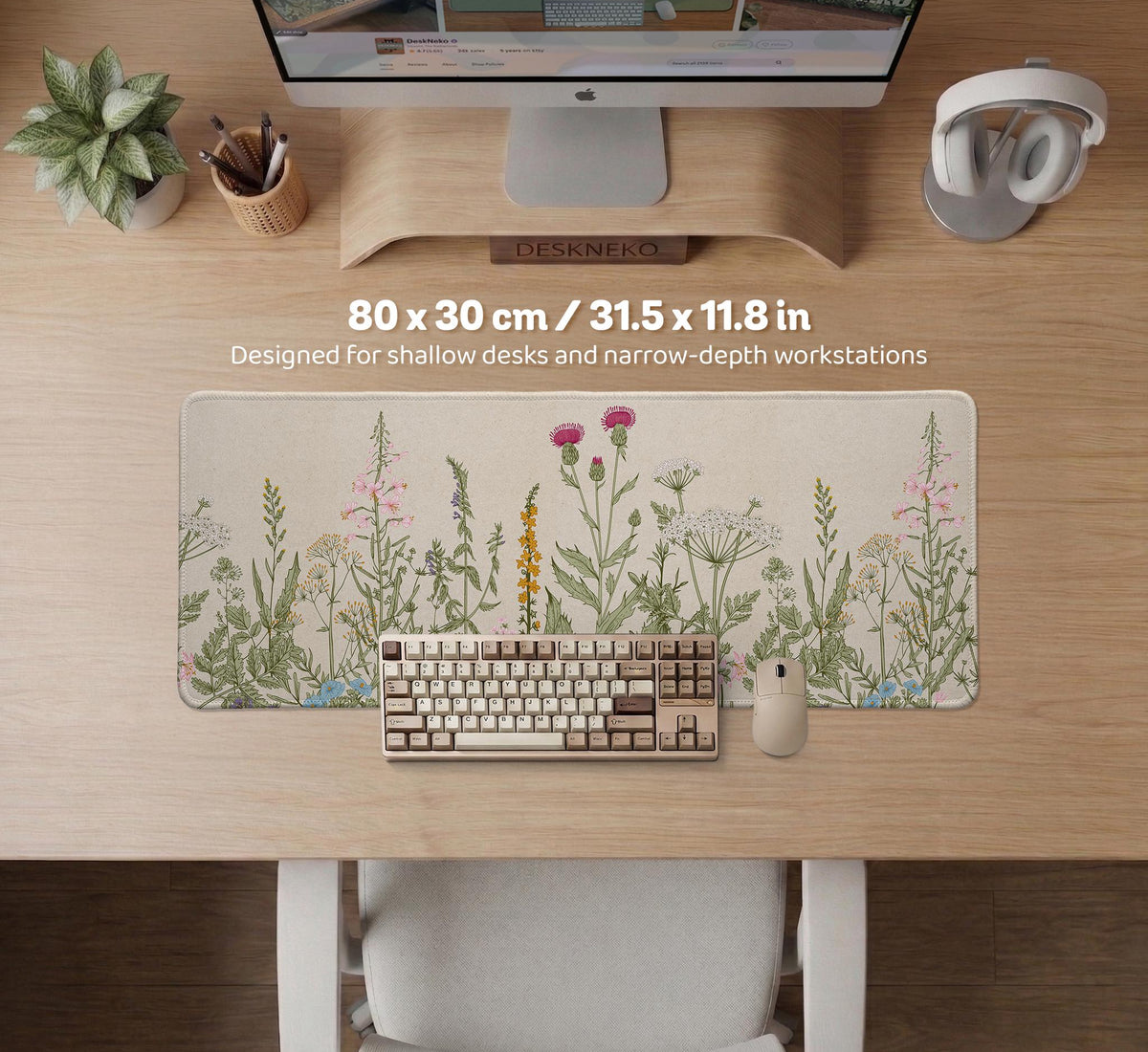 A desk mat with a botanical meadow design featuring wildflowers, leafy stems, and soft neutral colors.