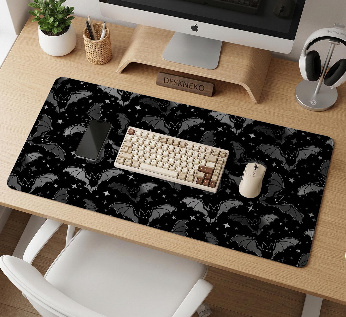 Black desk mat with a dark bat pattern and scattered stars on a charcoal background.