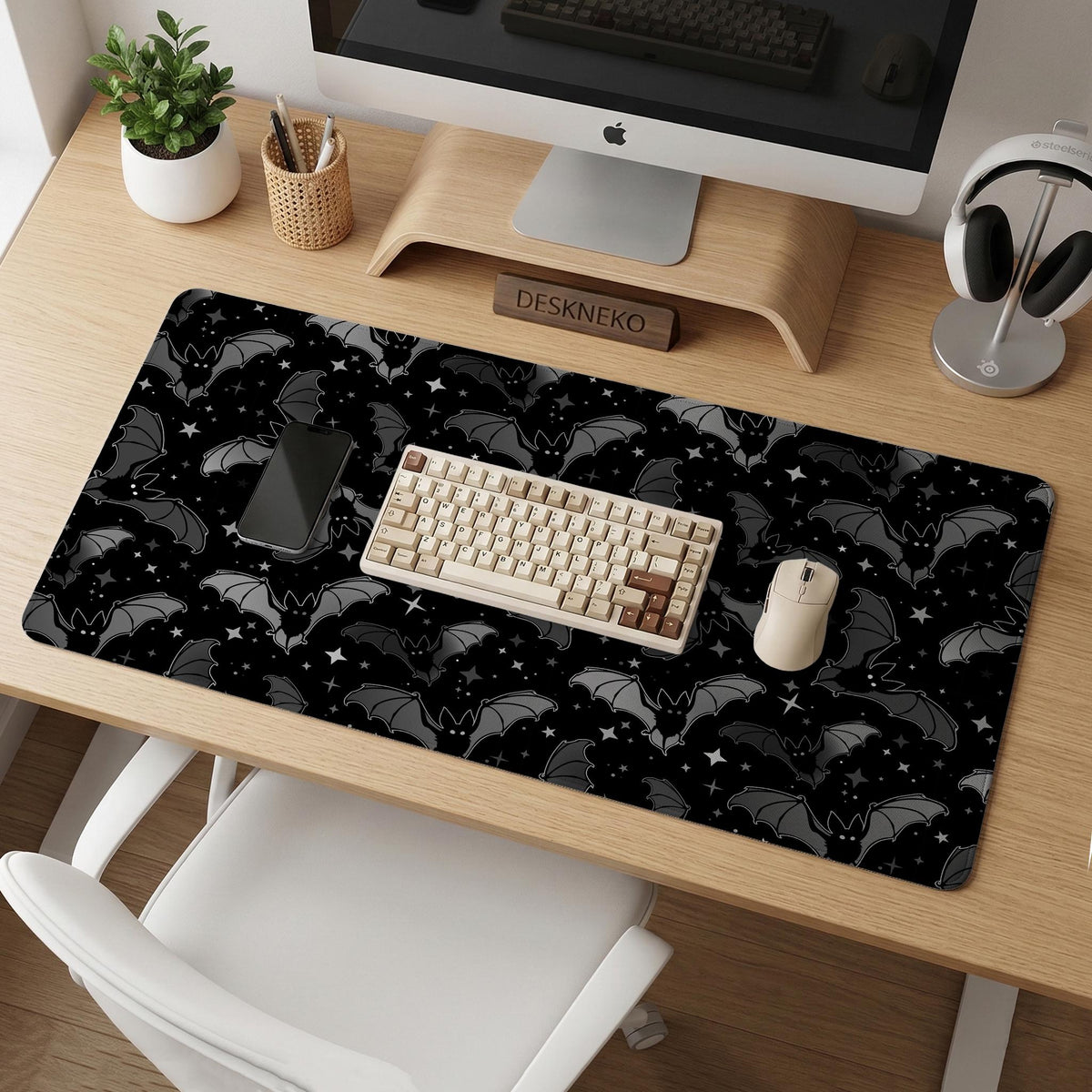 Black desk mat with a dark bat pattern and scattered stars on a charcoal background.