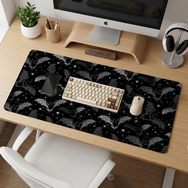 Black desk mat with a dark bat pattern and scattered stars on a charcoal background.