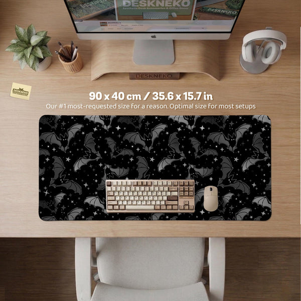 Black desk mat with a dark bat pattern and scattered stars on a charcoal background.