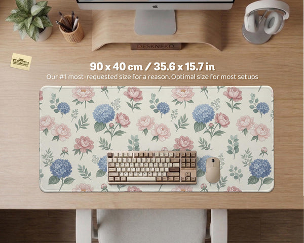 Floral desk mat with sage greenery, pink peonies, blue flowers, and a warm cream background.