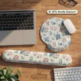 Floral desk mat with sage greenery, pink peonies, blue flowers, and a warm cream background.