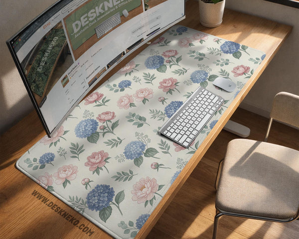 Floral desk mat with sage greenery, pink peonies, blue flowers, and a warm cream background.