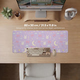Lavender desk mat with an all-over pattern of bunny faces, clouds, moons, bows, and flowers in pastel colors.