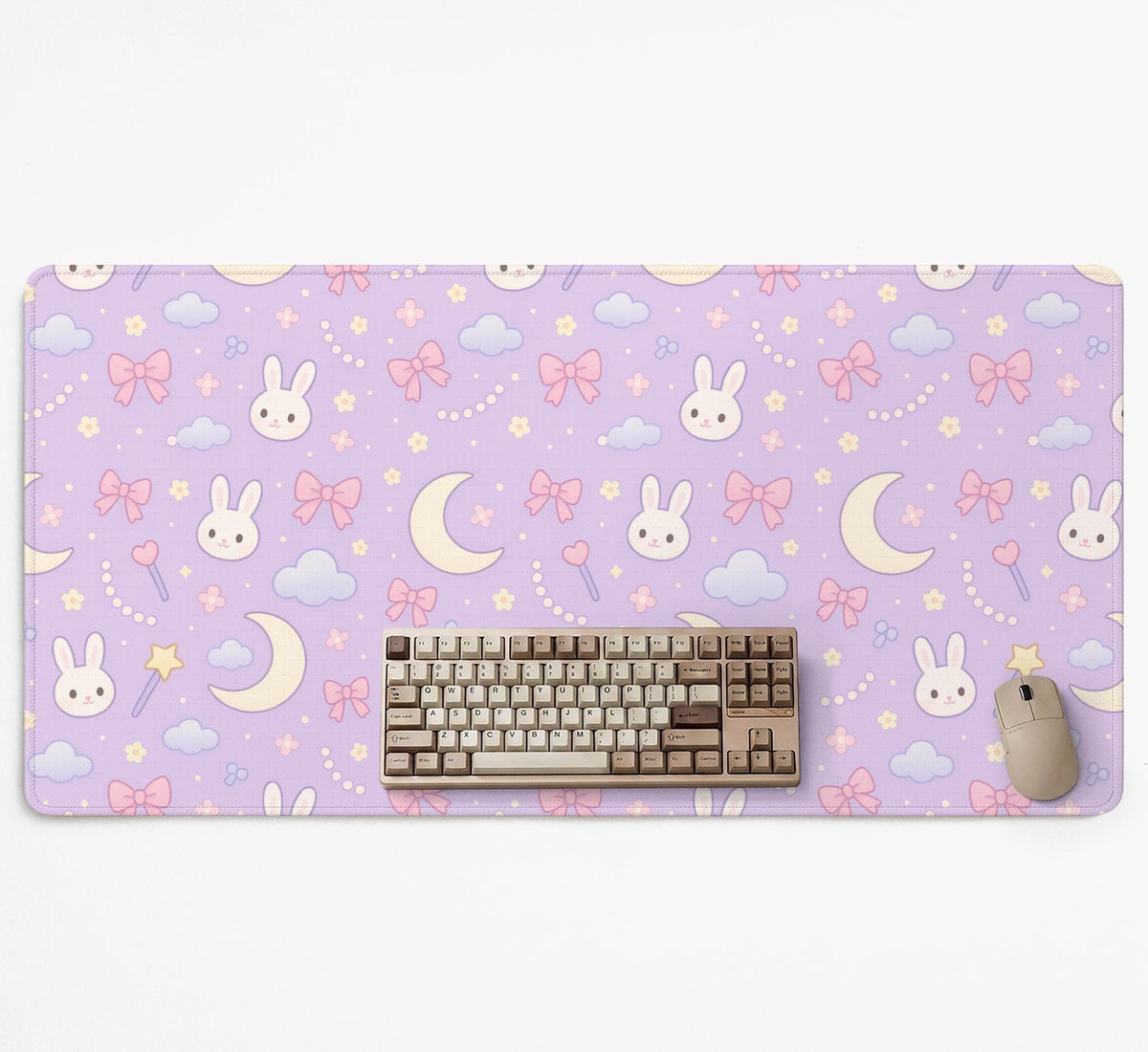 Pastel lavender desk mat with an all-over pattern of bunnies, crescent moons, clouds, bows, stars, and small flowers.