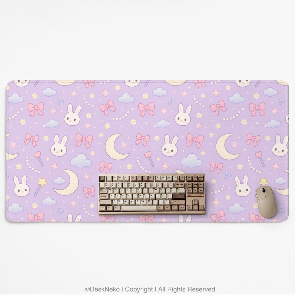 Lavender desk mat with an all-over pattern of bunny faces, clouds, moons, bows, and flowers in pastel colors.