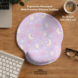 Lavender desk mat with an all-over pattern of bunny faces, clouds, moons, bows, and flowers in pastel colors.
