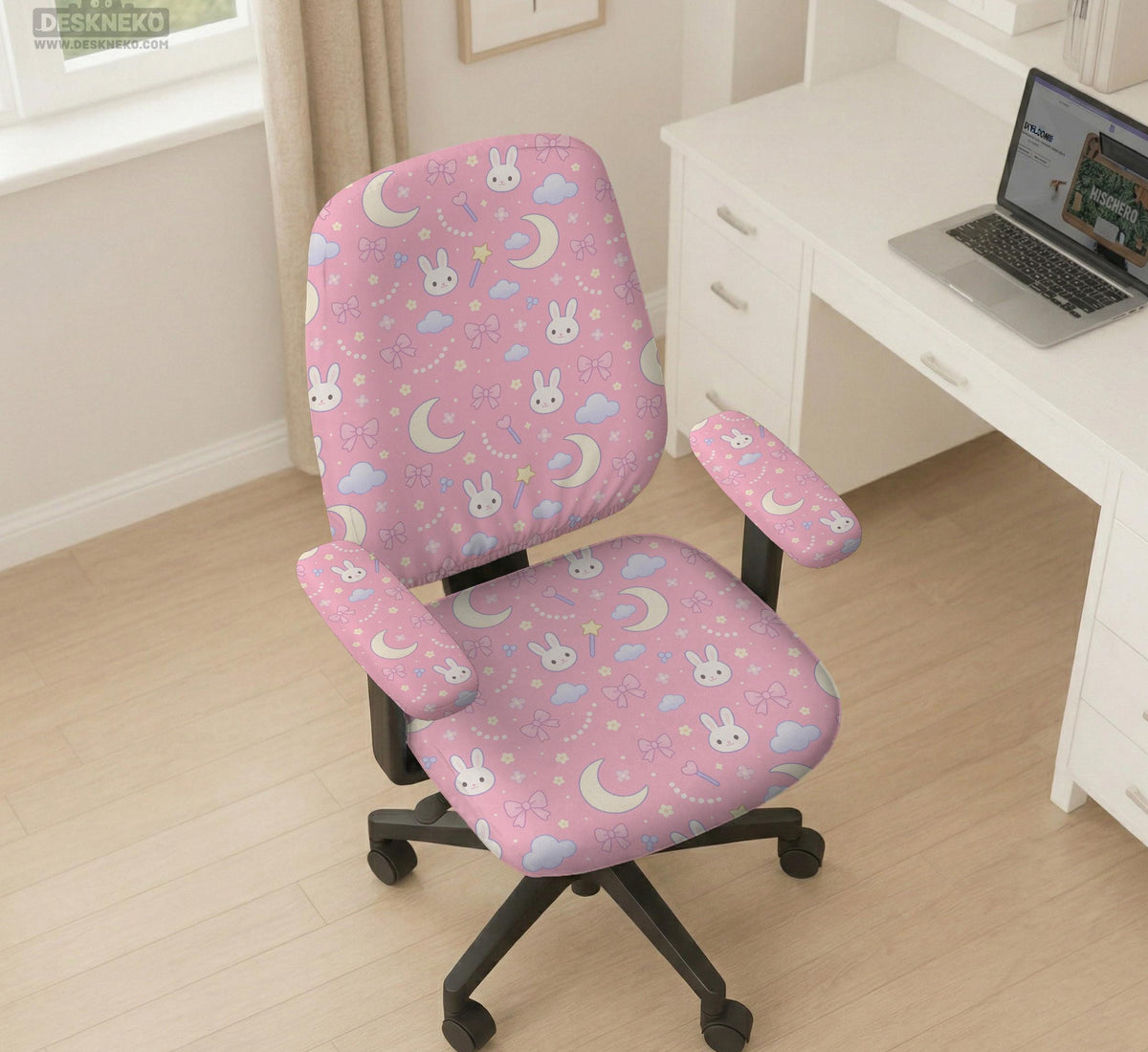 Pink chair cover with bunny faces, crescent moons, clouds, and bows on a white chair.