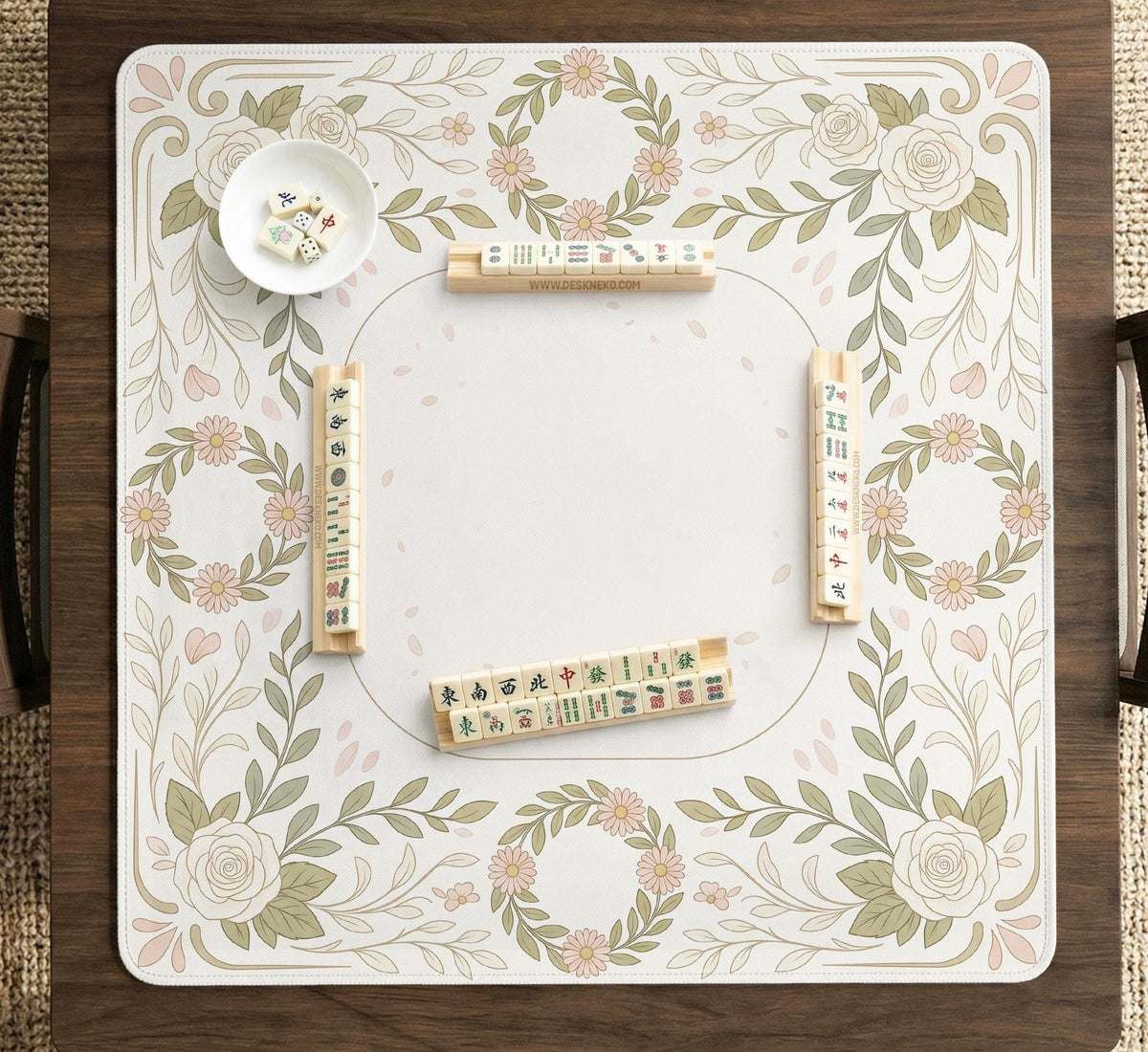 Square mahjong mat with a light floral border in sage green, cream, and blush around a plain center play area.