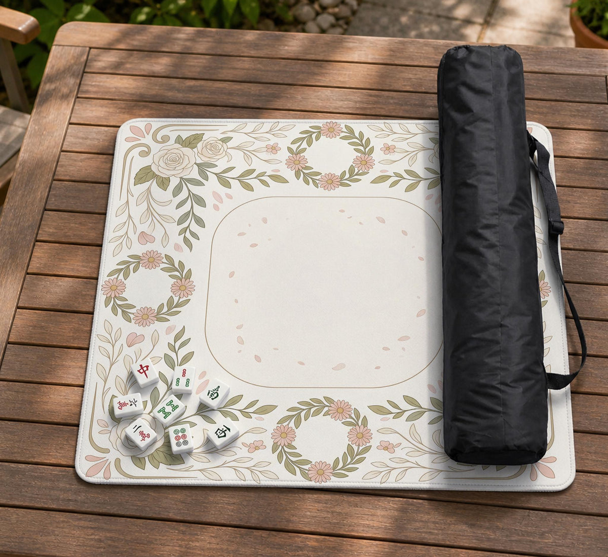 Square mahjong mat with a light floral border in sage green, cream, and blush around a plain center play area.