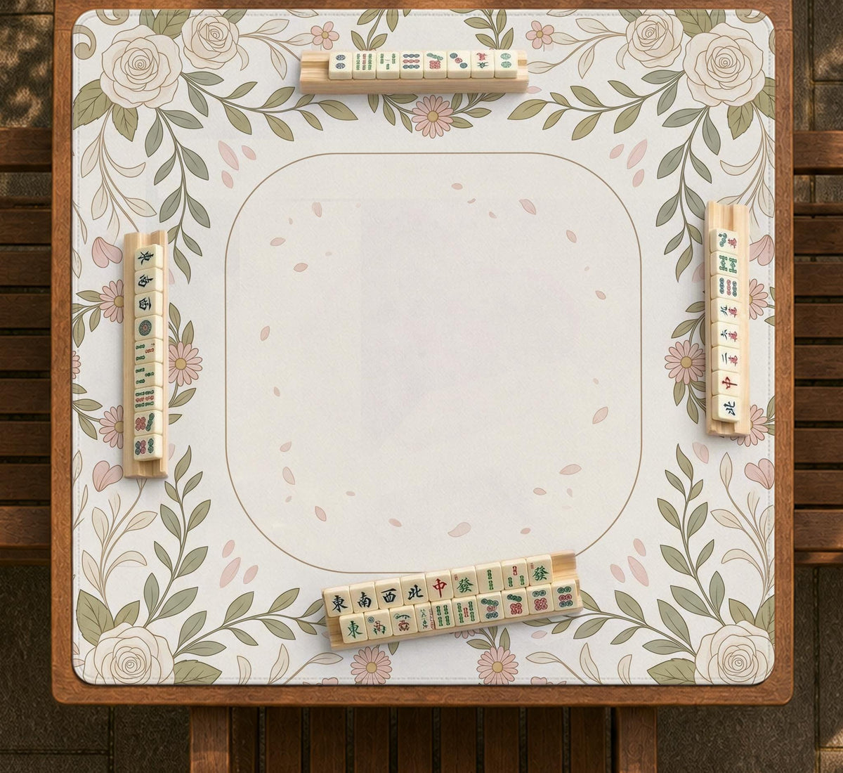 Square mahjong mat with a light floral border in sage green, cream, and blush around a plain center play area.