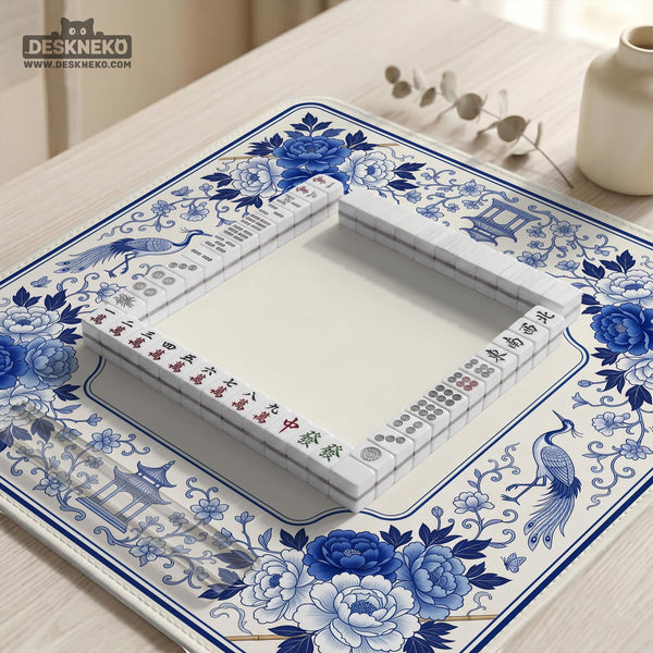 Square blue and white mahjong mat with peonies, cranes, pagoda accents, and chinoiserie linework around a plain center.