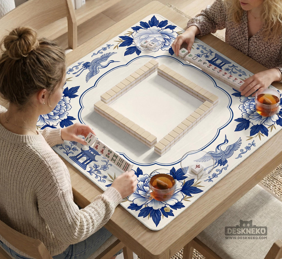 Blue and white mahjong mat with cranes, floral porcelain-style artwork, a cream center area, and a decorative border.