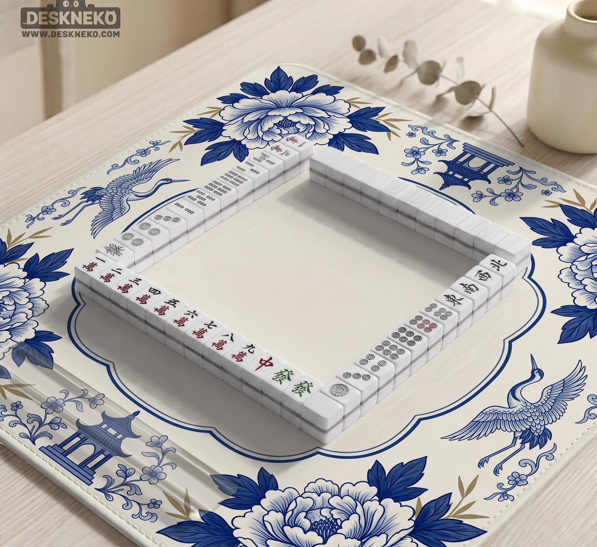 Blue and white mahjong mat with cranes, floral porcelain-style artwork, a cream center area, and a decorative border.