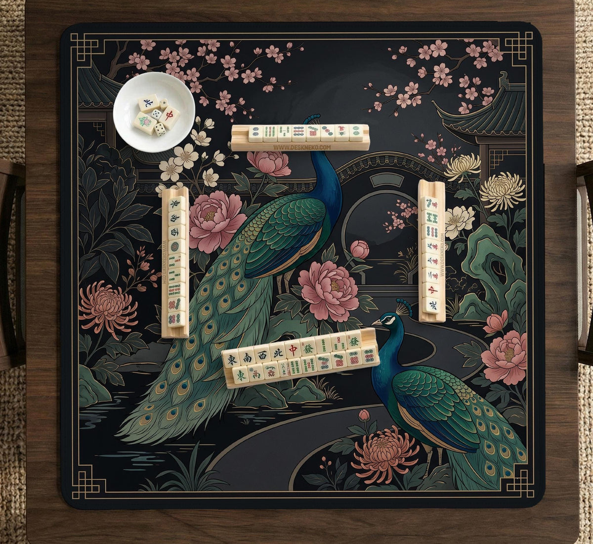 Square black mahjong mat with a gold peacock, blush flowers, and dark botanical artwork on a dark background.