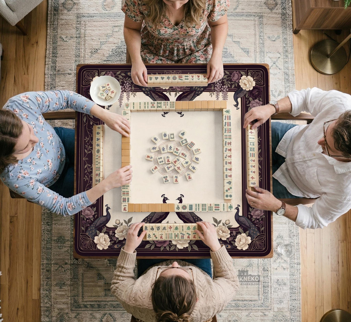 Square mahjong mat with a dark plum border, ivory floral pattern, muted sage leaves, and a decorative peacock garden design.