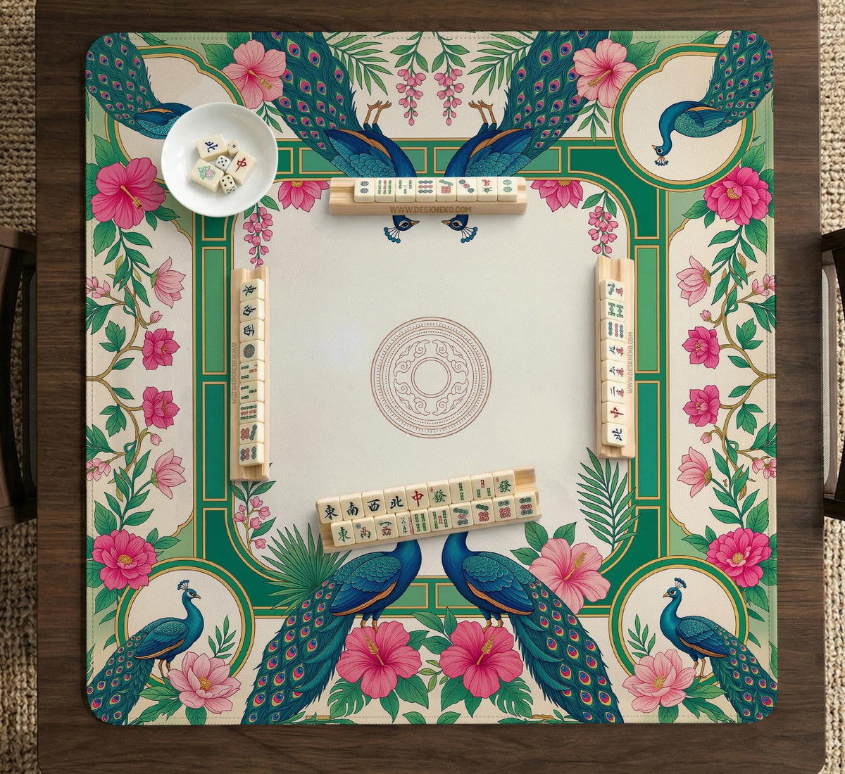Green mahjong mat with peacocks, hibiscus flowers, tropical leaves, cream center space, and a scalloped floral border.