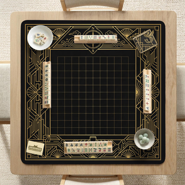 Black and gold square mahjong mat with a scalloped edge, geometric border, thin line details, fan motifs, and dragon and phoenix accents around an open center.