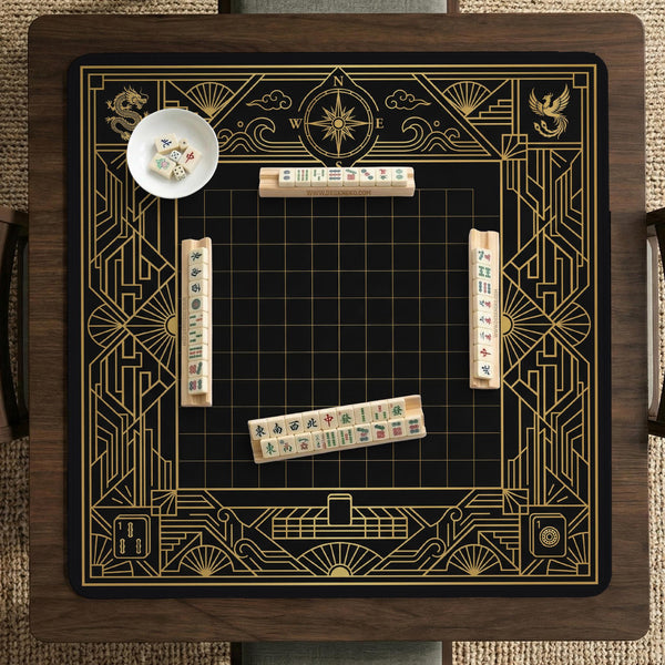 Black and gold square mahjong mat with a scalloped edge, geometric border, thin line details, fan motifs, and dragon and phoenix accents around an open center.
