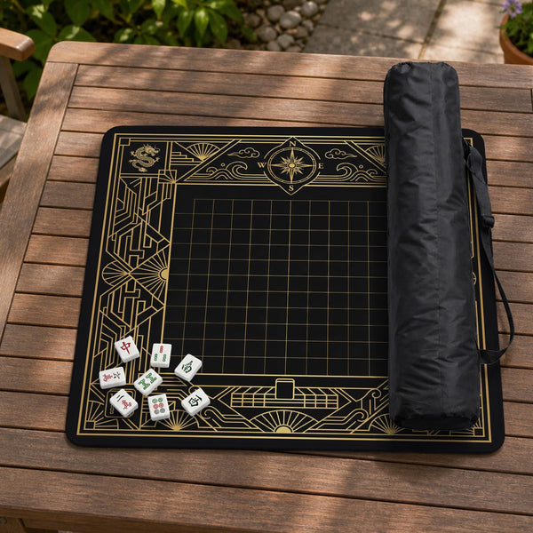 Black and gold square mahjong mat with a scalloped edge, geometric border, thin line details, fan motifs, and dragon and phoenix accents around an open center.