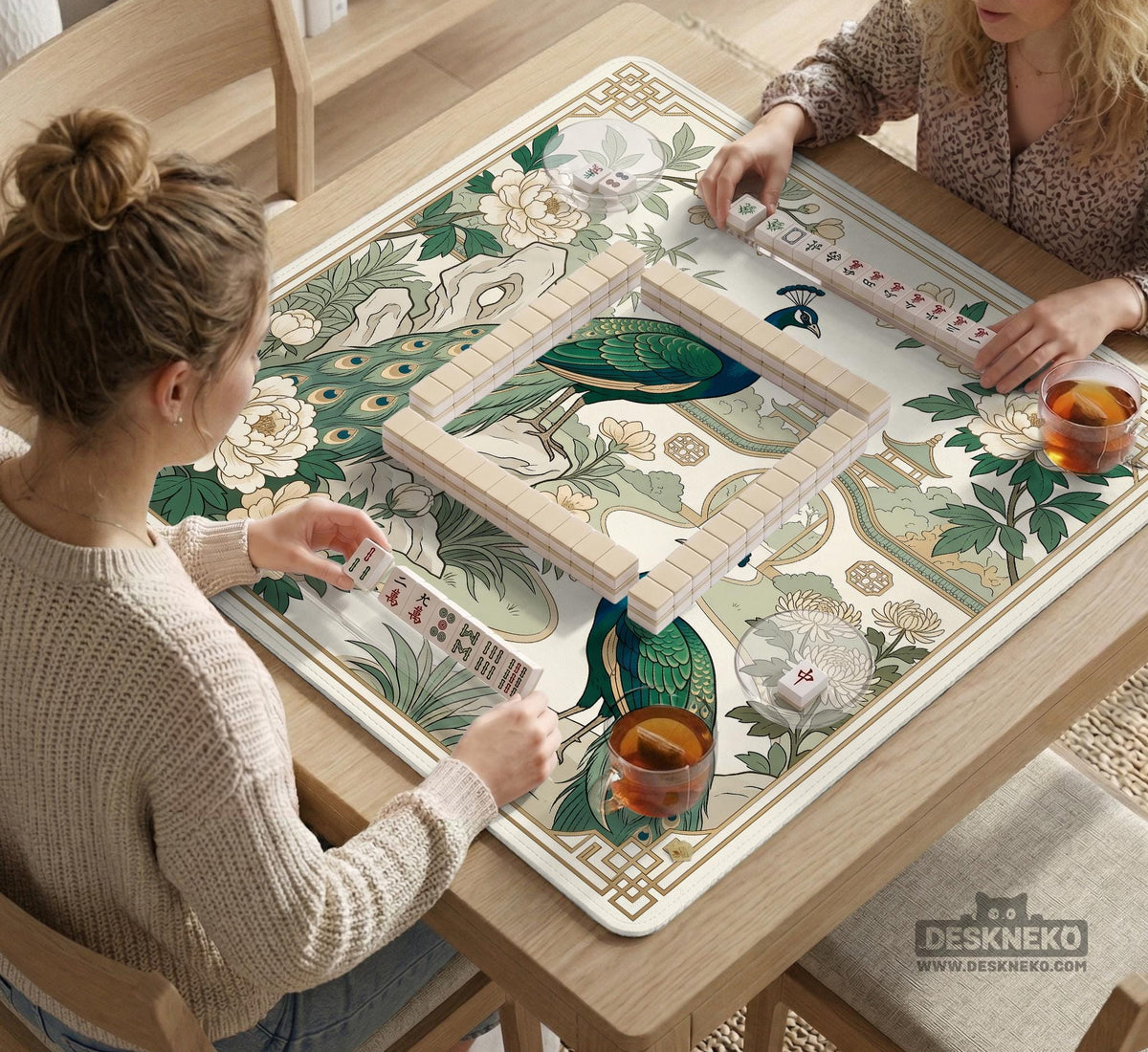 A green mahjong mat with peacock, floral, bamboo, pagoda, and gold border artwork in a scalloped chinoiserie style.