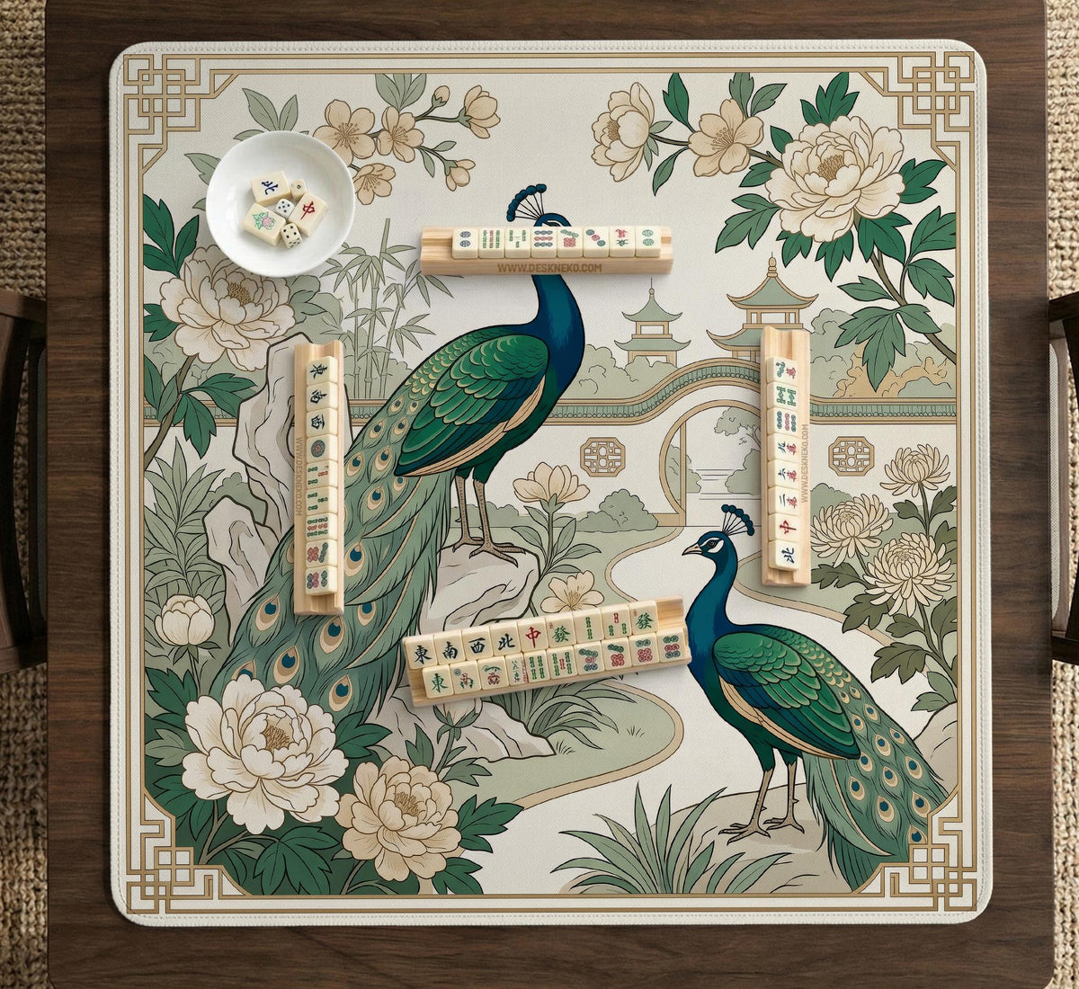 A green mahjong mat with peacock, floral, bamboo, pagoda, and gold border artwork in a scalloped chinoiserie style.
