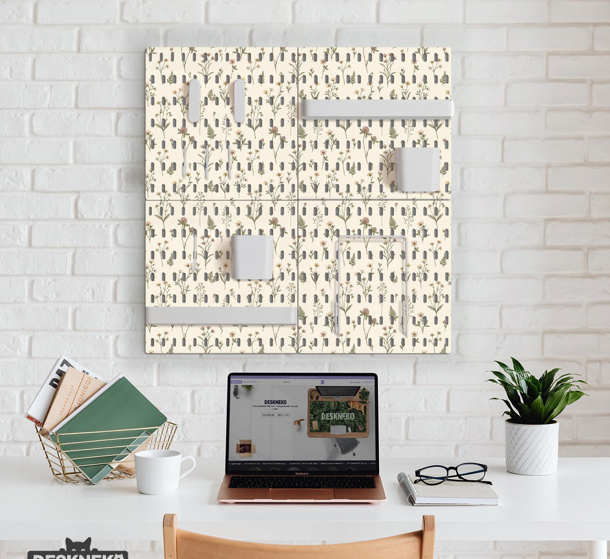 Cream pegboard wall organizer with small floral print, sage green stems, black slot layout, shelves, hooks, clips, and containers.