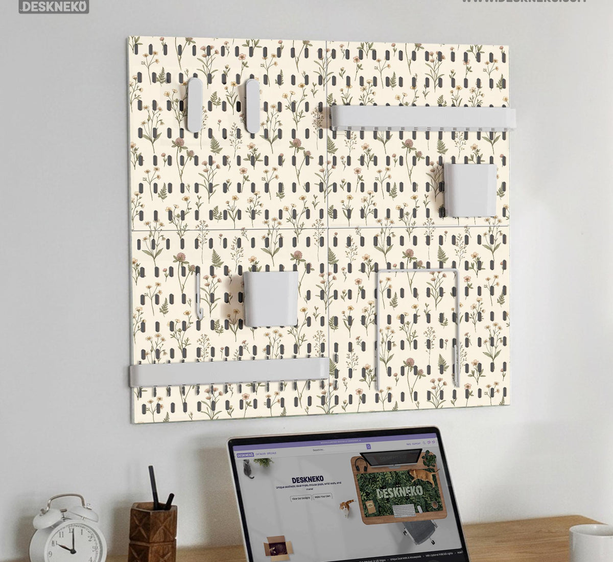 Cream pegboard wall organizer with small floral print, sage green stems, black slot layout, shelves, hooks, clips, and containers.