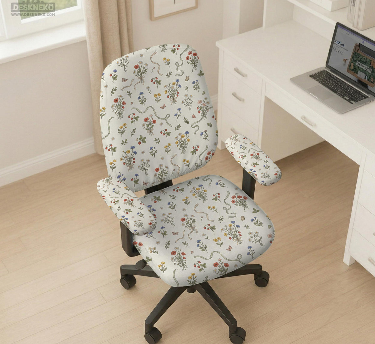 Cream chair cover with a scattered cottage garden floral print in red, blue, yellow, and green on a light background.