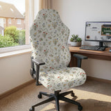 Cream chair cover with a scattered cottage garden floral print in red, blue, yellow, and green on a light background.