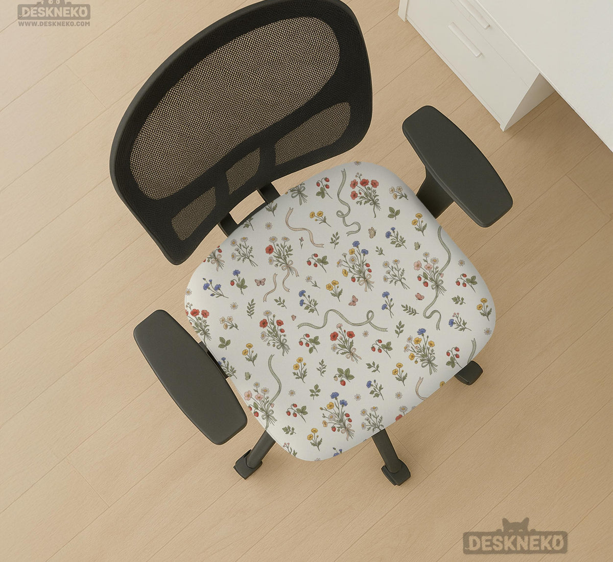 Cream chair cover with a scattered cottage garden floral print in red, blue, yellow, and green on a light background.