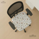 Cream chair cover with a scattered cottage garden floral print in red, blue, yellow, and green on a light background.