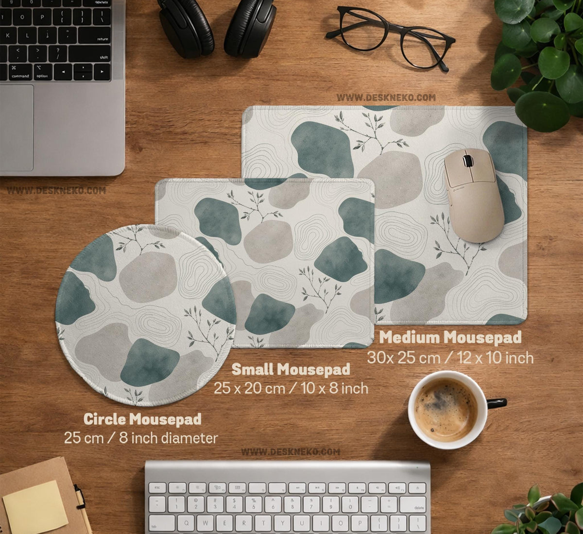 A desk mat with sage green abstract blocks, cream space, gray stone-like shapes, fine topographic contour lines, and small branch details.