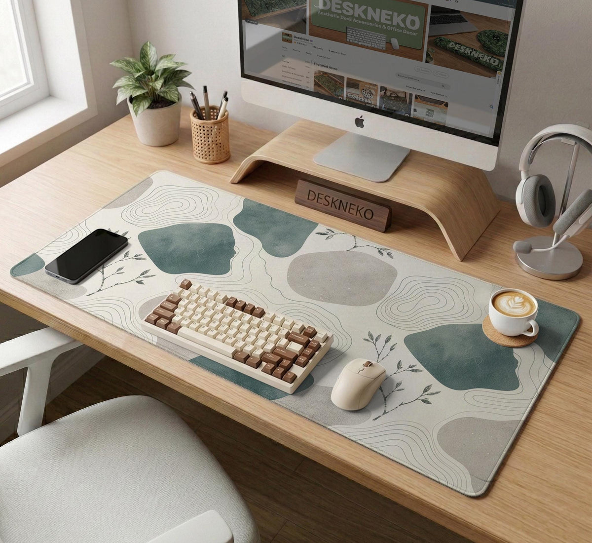 A desk mat with sage green abstract blocks, cream space, gray stone-like shapes, fine topographic contour lines, and small branch details.