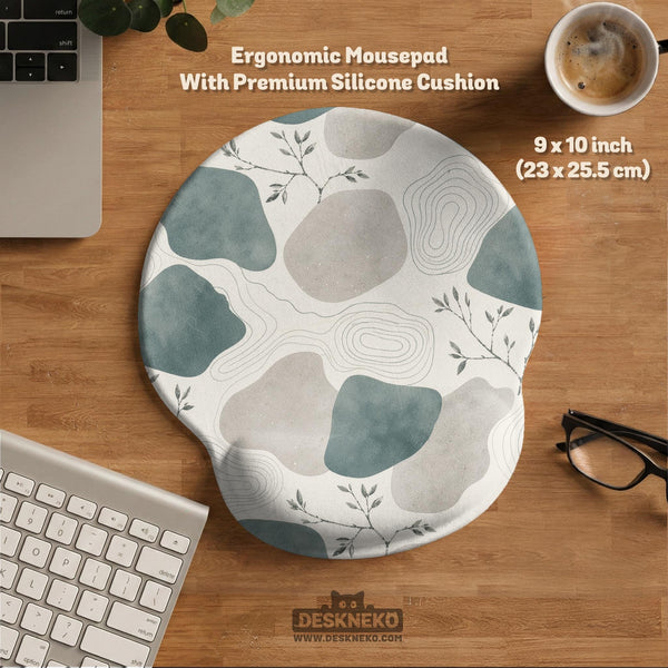 A desk mat with sage green abstract blocks, cream space, gray stone-like shapes, fine topographic contour lines, and small branch details.