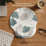 Sage green ergonomic mousepad and keyboard wrist rest with abstract shapes, soft gray details, cream space, topographic contour lines, and leafy branch accents.
