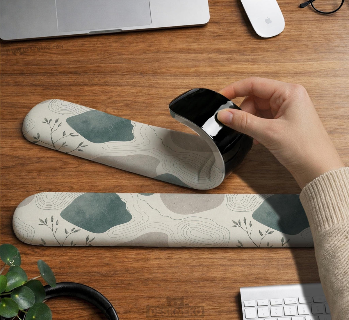Sage green ergonomic mousepad and keyboard wrist rest with abstract shapes, soft gray details, cream space, topographic contour lines, and leafy branch accents.