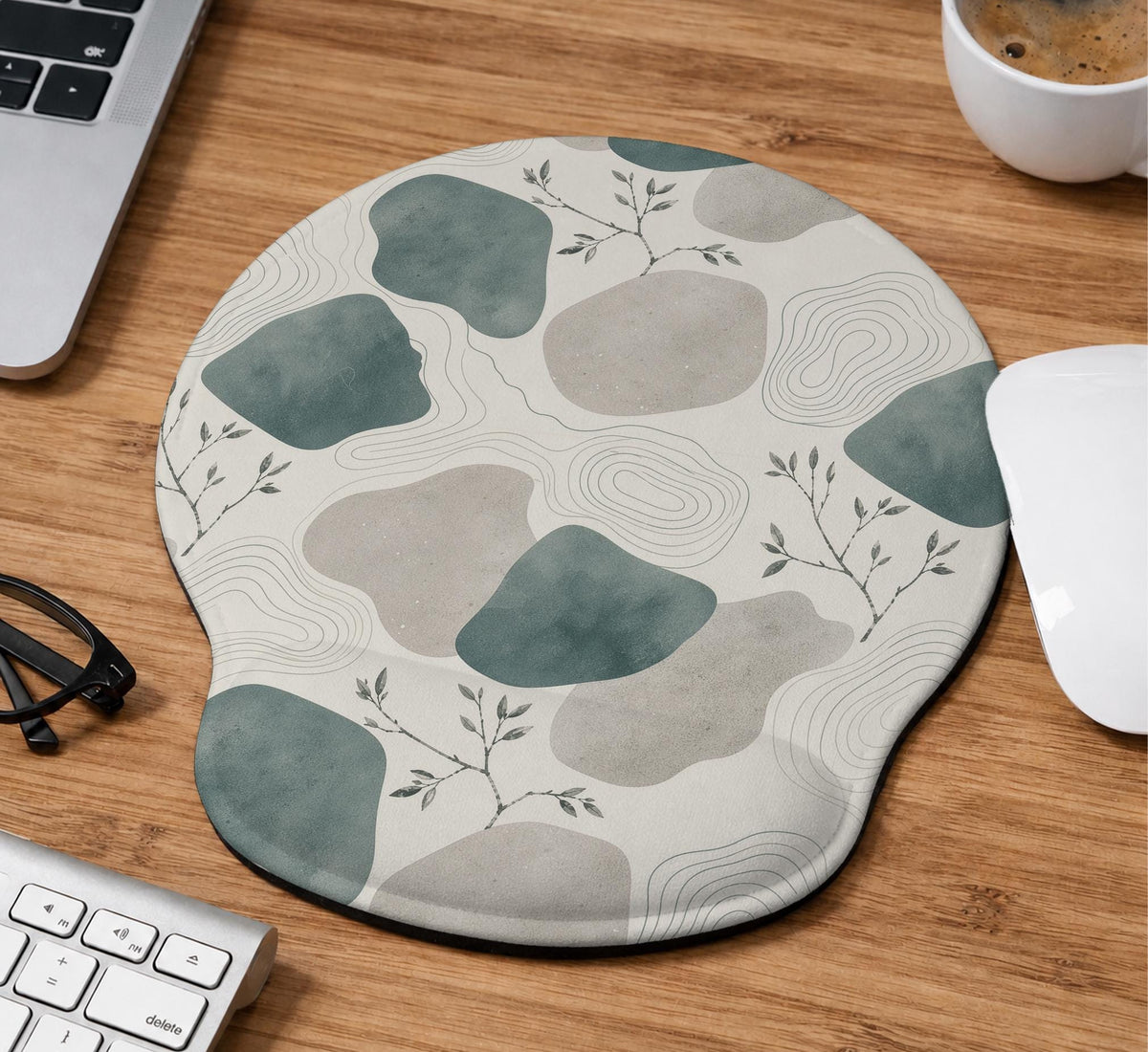 Sage green ergonomic mousepad and keyboard wrist rest with abstract shapes, soft gray details, cream space, topographic contour lines, and leafy branch accents.