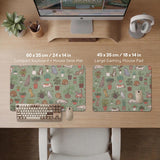 A desk mat with a repeating pattern of cats, leafy houseplants, cactus pots, and small plant-shop style details in sage green.