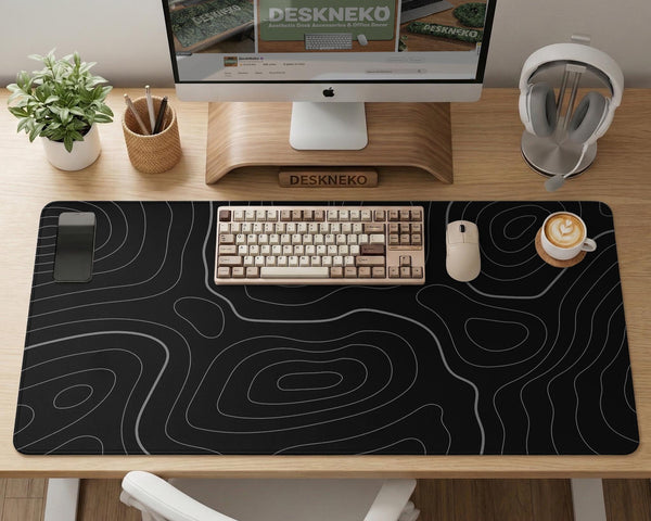 Black desk mat with a thin gray topographic contour line pattern.