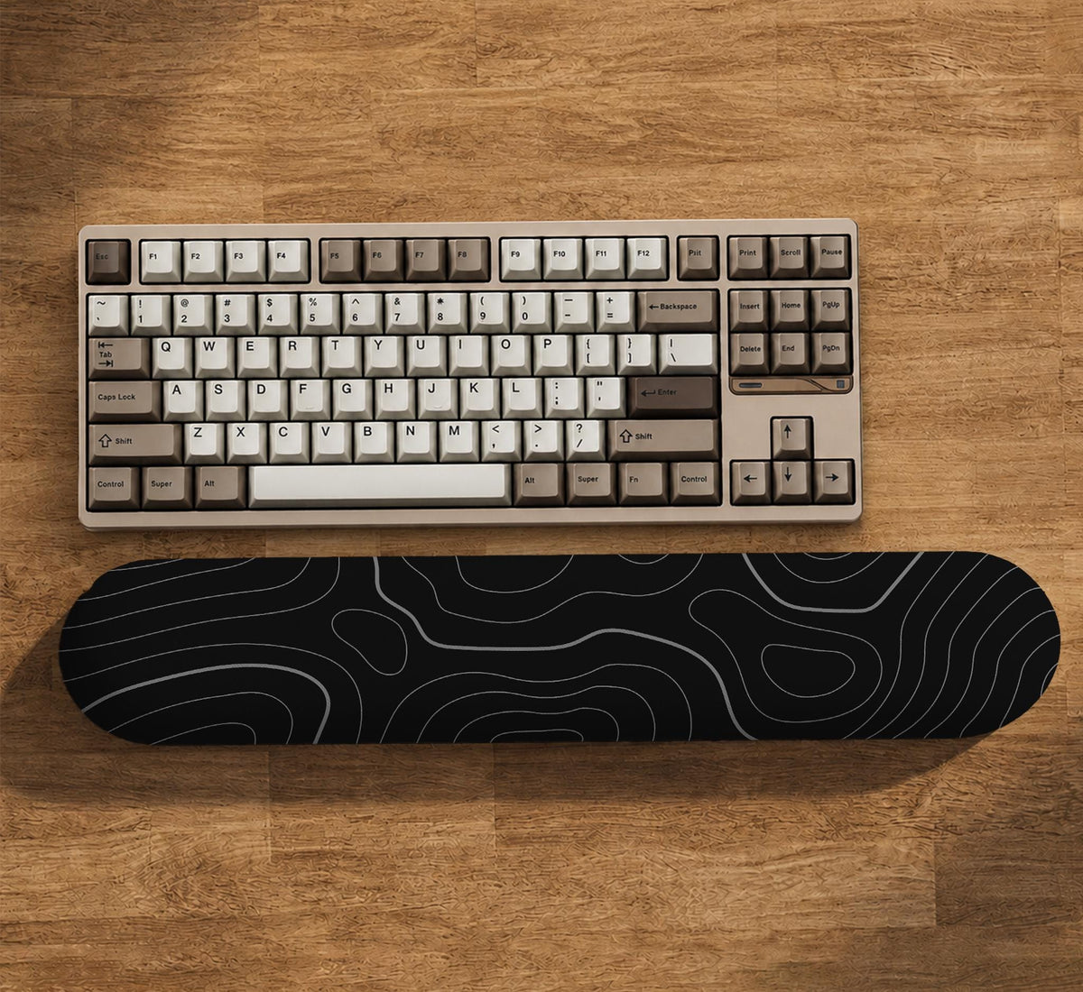 Black mousepad with a gray topographic contour line pattern shown with matching keyboard wrist rest options.