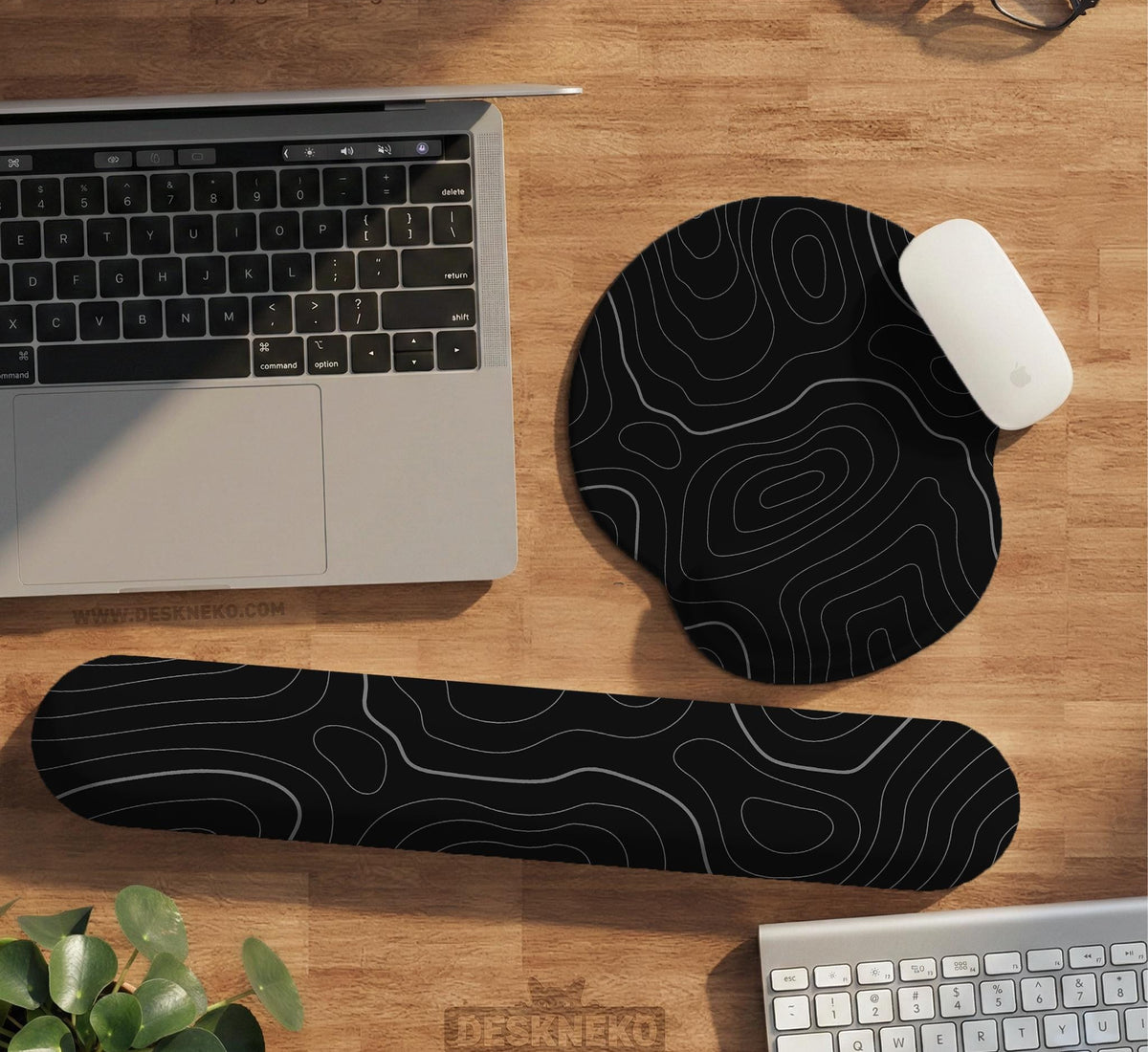 Black mousepad with a gray topographic contour line pattern shown with matching keyboard wrist rest options.