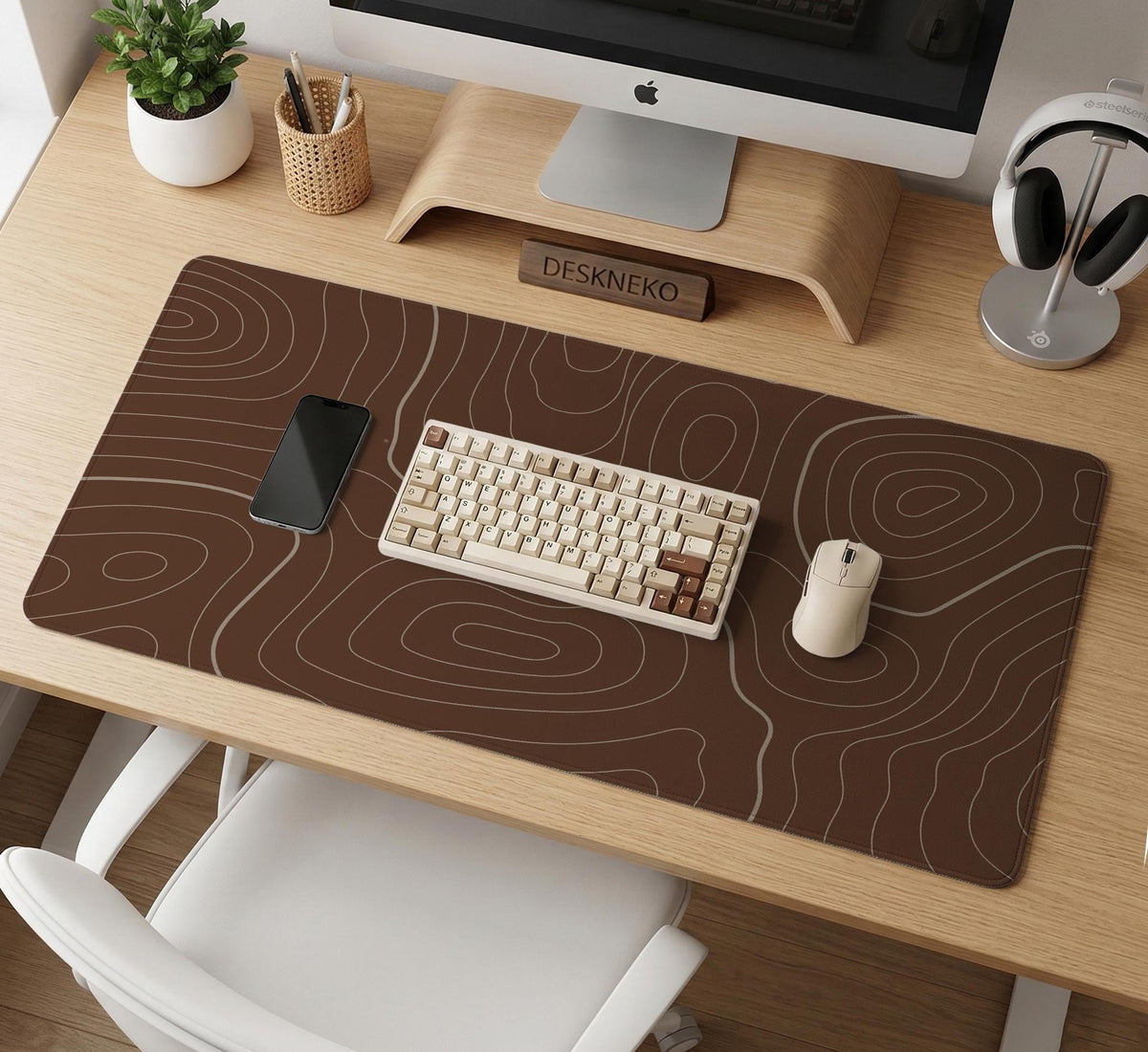 Brown desk mat with a repeating topographic contour line pattern in a neutral earth tone design.