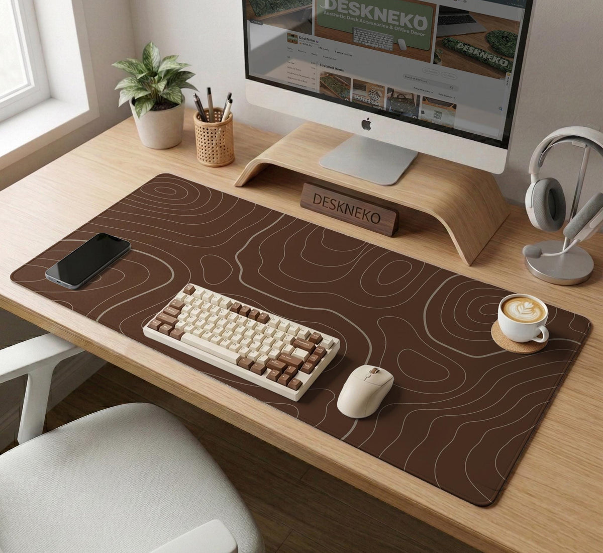 Brown desk mat with a repeating topographic contour line pattern in a neutral earth tone design.