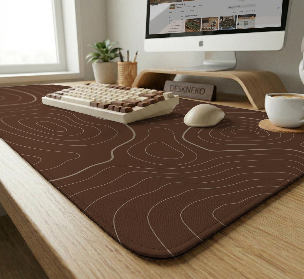 Brown desk mat with a repeating topographic contour line pattern in a neutral earth tone design.