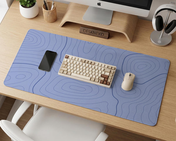 A pastel blue mousepad with an abstract topographic contour line pattern.