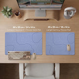 A periwinkle deskmat with thin blue contour lines printed across the surface.