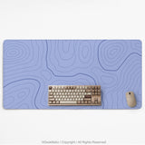 A periwinkle deskmat with thin blue contour lines printed across the surface.